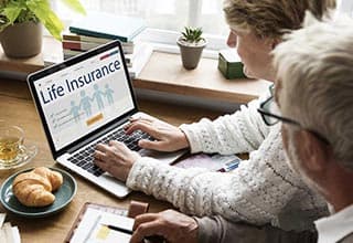 man and woman using computer to shop for life insurance